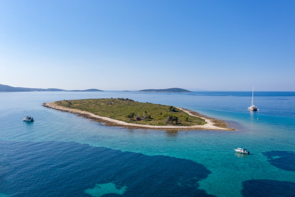 green and brown grass field near blue sea under blue sky during daytime