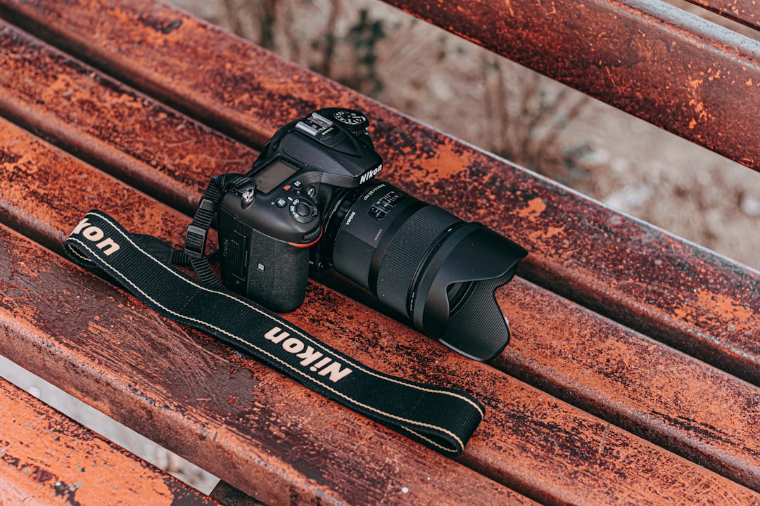 black nikon dslr camera on brown wooden surface