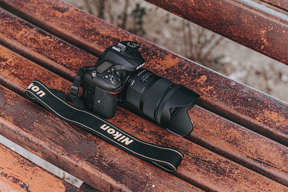 Fotocamera reflex digitale Nikon nera su superficie in legno marrone