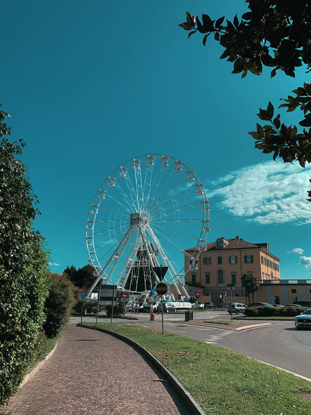 white ferris wheel near brown concrete building during daytime