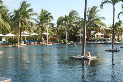 An inviting outdoor pool and whirlpool surrounded by comfortable loungers and tropical plants.