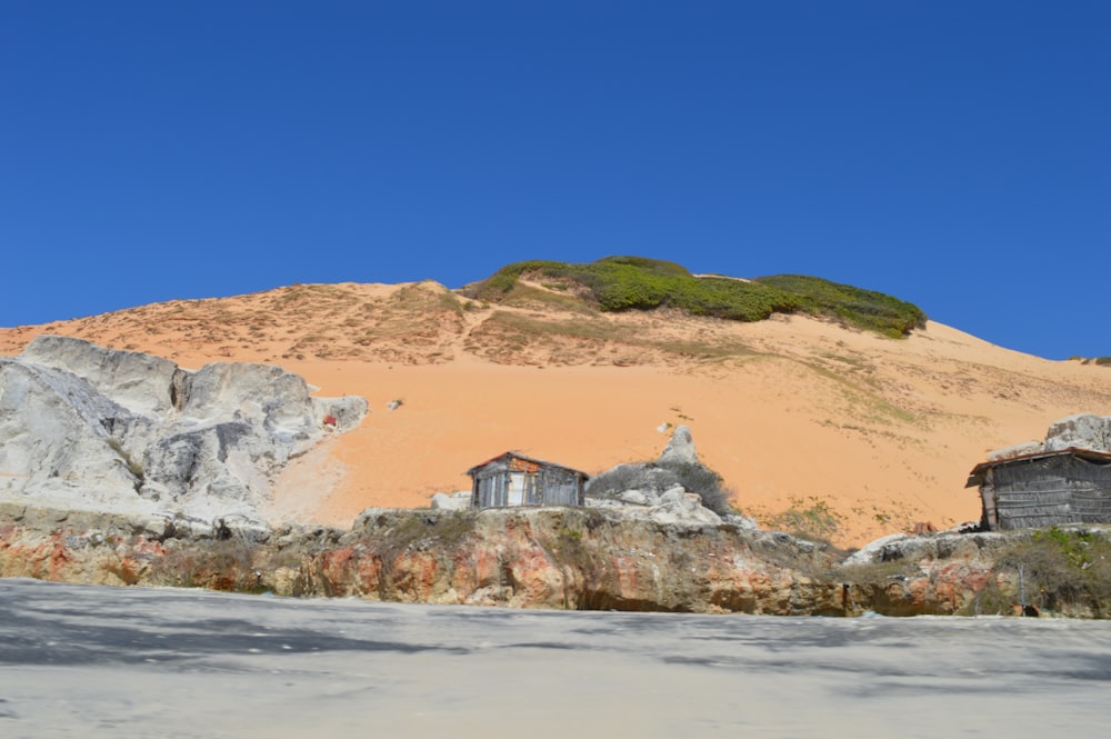 Casa marrón y blanca en la colina marrón bajo el cielo azul durante el día