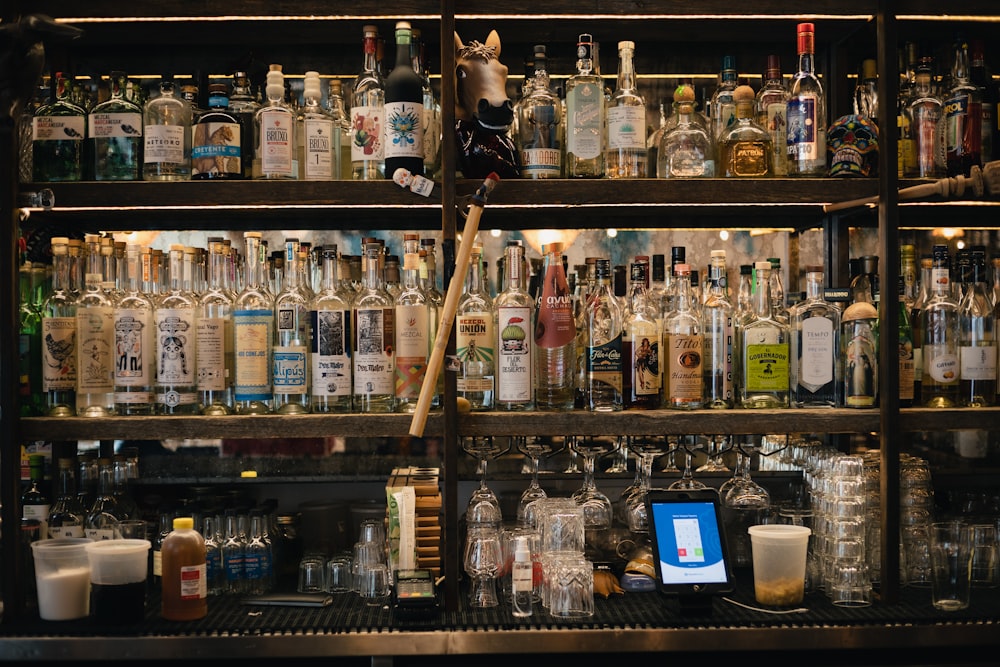 clear glass bottles on brown wooden shelf