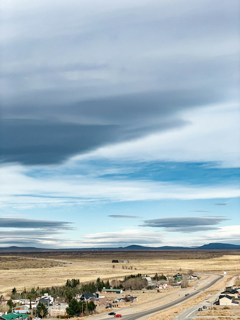 brown field under blue sky and white clouds during daytime