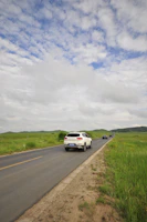 Spacious white SUV loaded with luggage near a countryside backdrop.