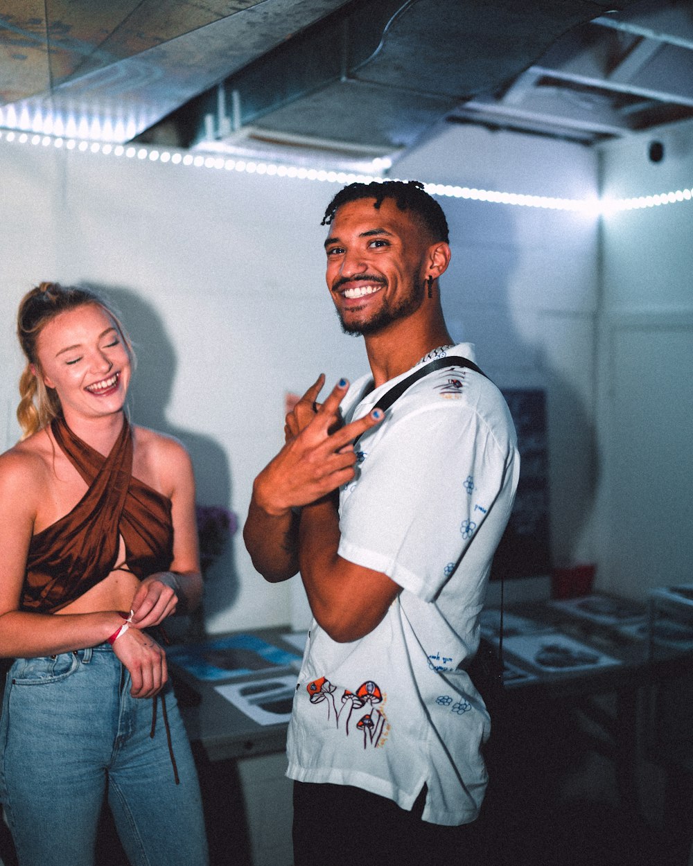 man in blue dress shirt beside woman in black tank top