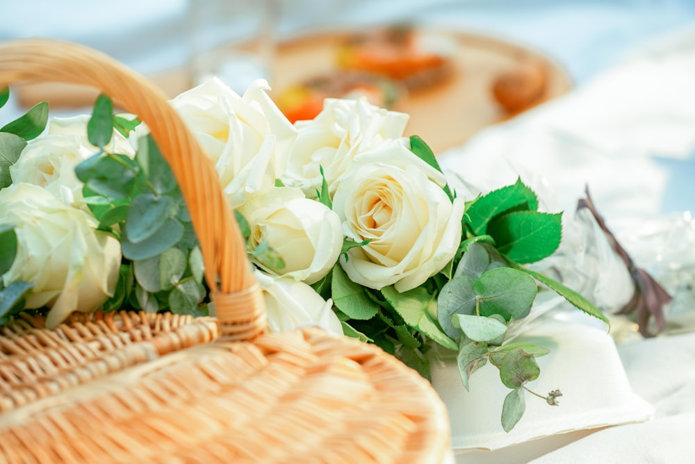 white roses in brown woven basket