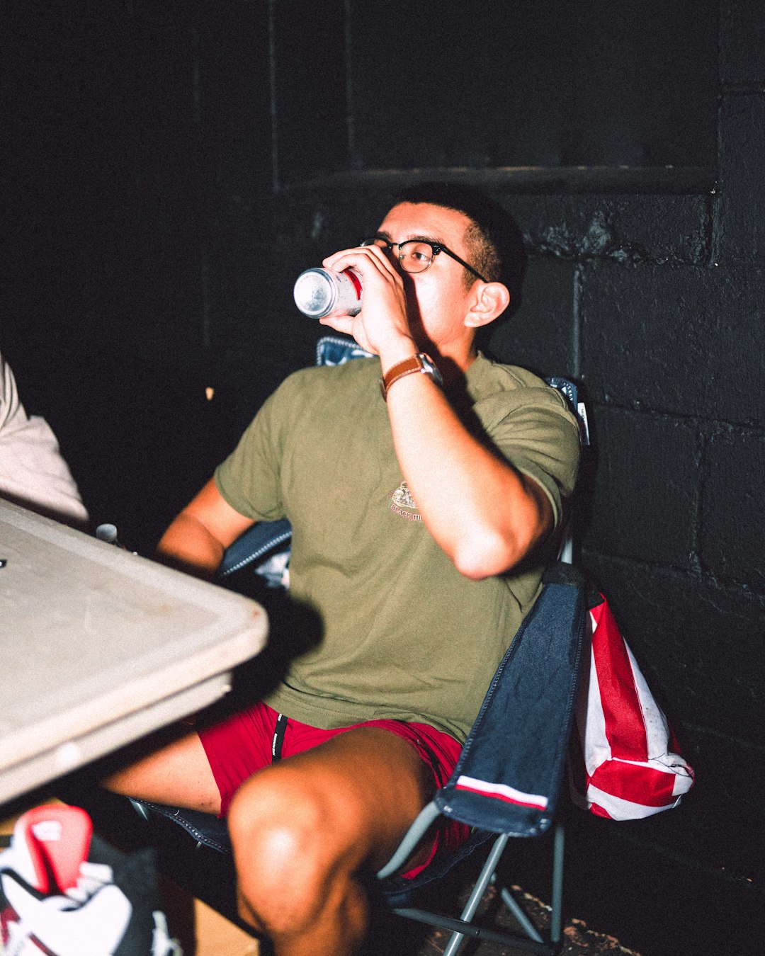 man in green crew neck t-shirt sitting on red chair