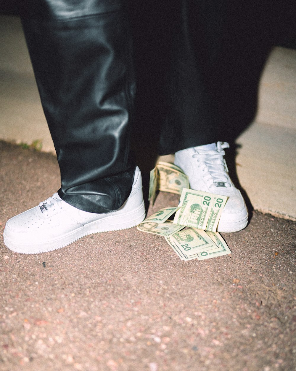 person in black pants and white and black nike sneakers