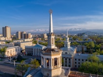 white concrete tower near city buildings during daytime