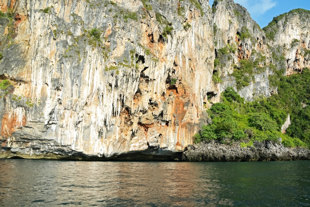 brown and white rock formation on body of water during daytime