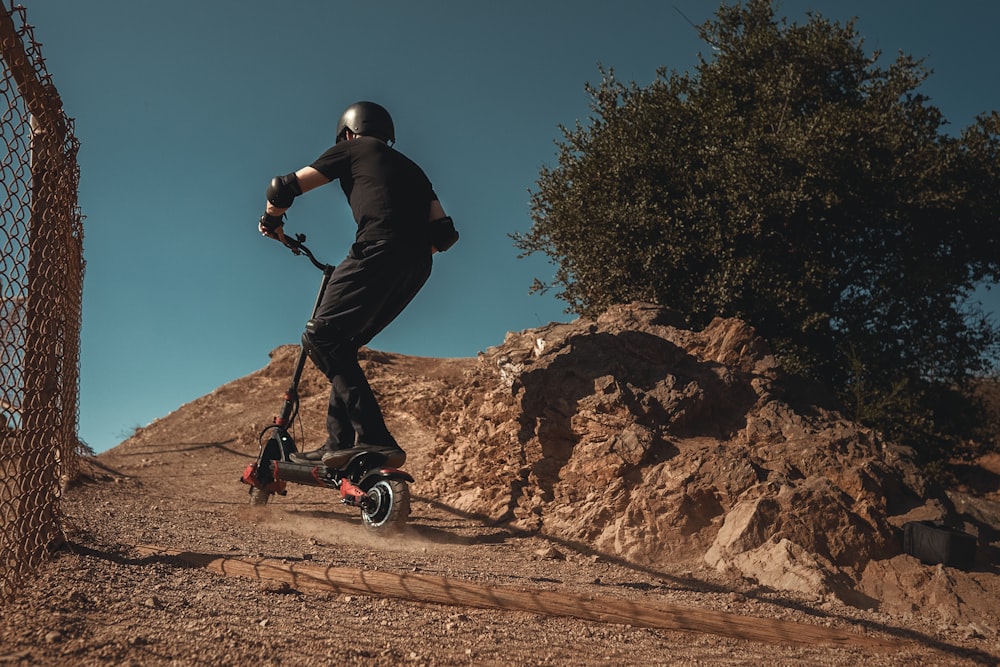 man in black jacket and black pants riding on black and white bicycle during daytime