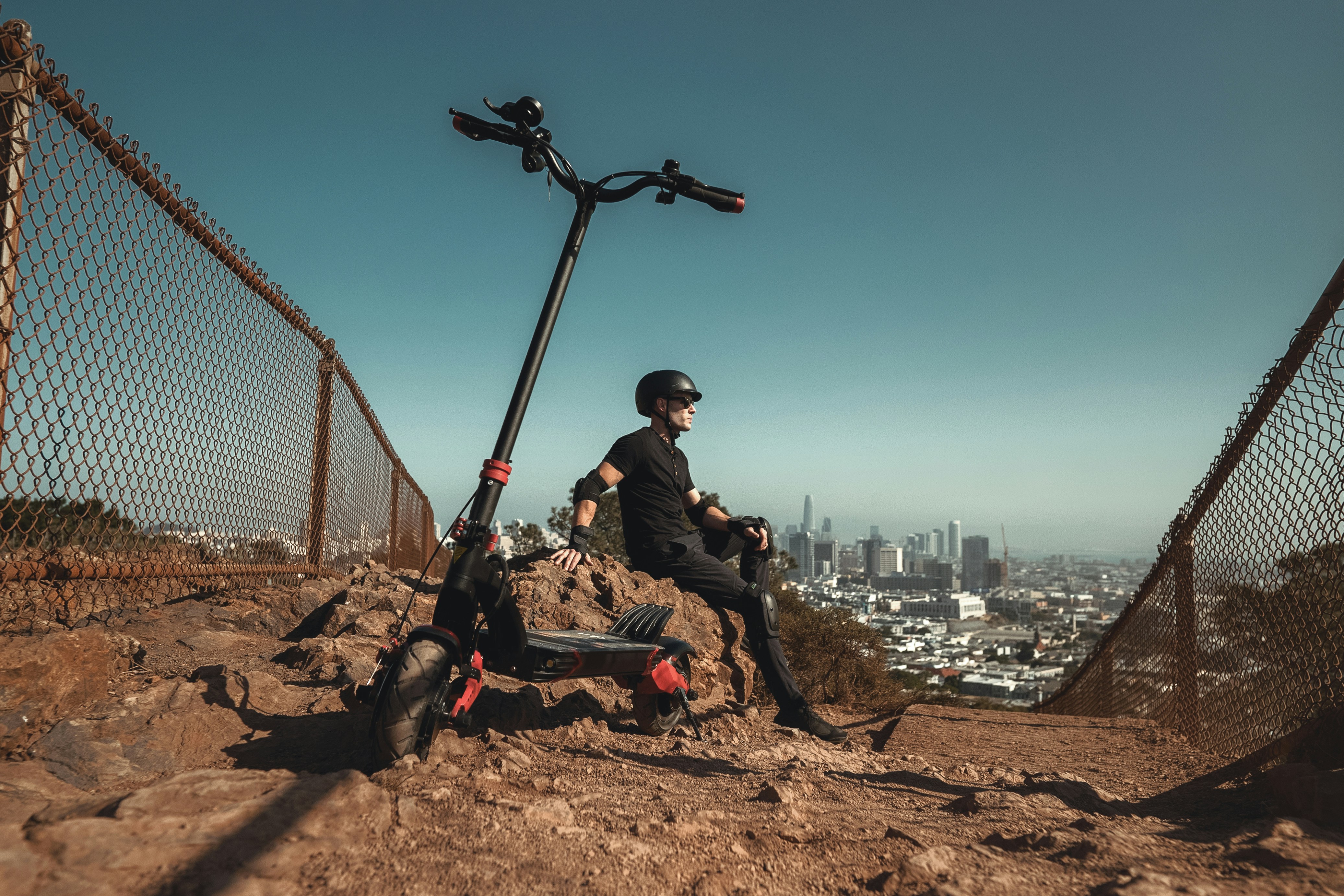 man in black jacket sitting on brown rock during daytime