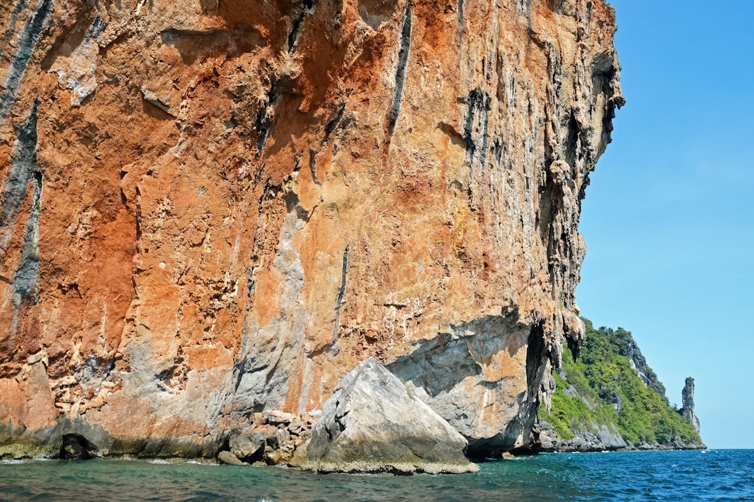 brown rock formation on body of water during daytime