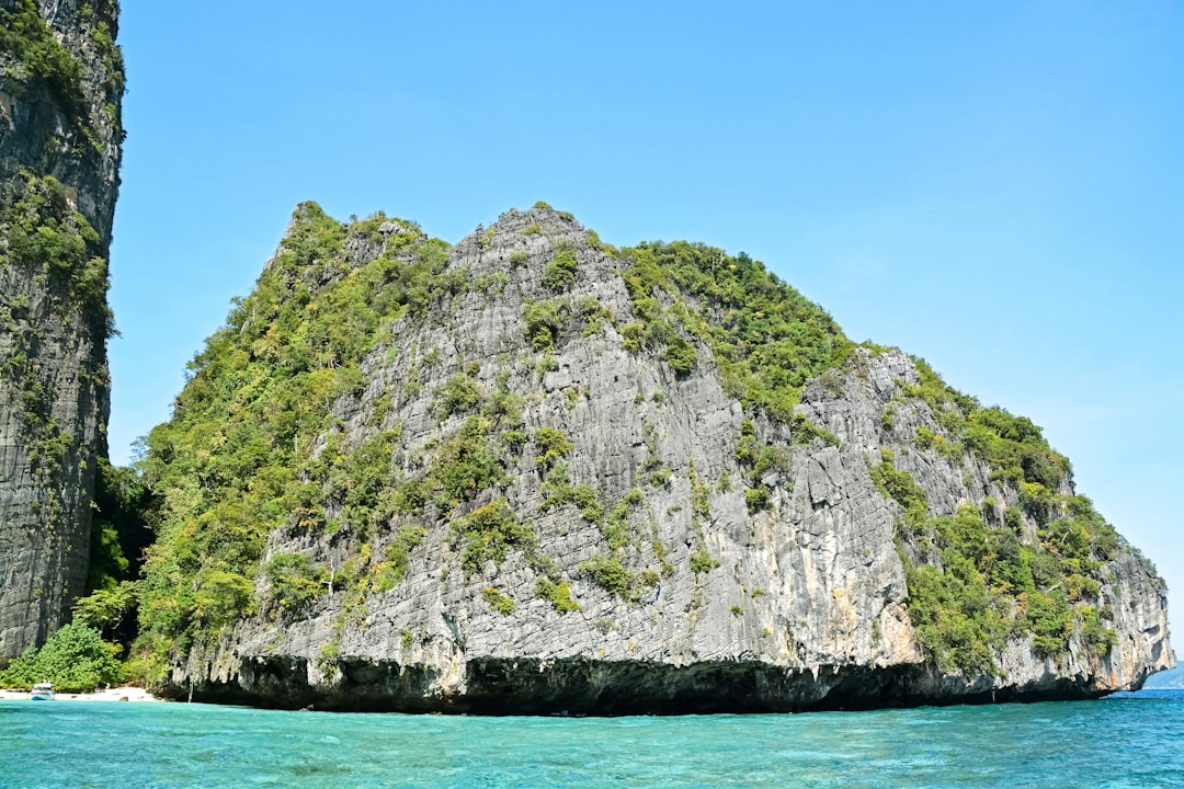 green and gray rock formation on blue sea under blue sky during daytime