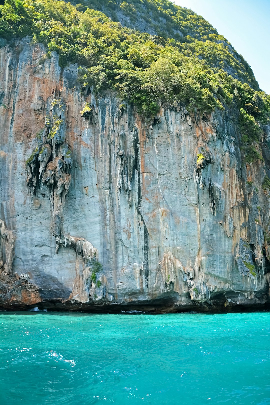 gray and green rock formation on blue sea during daytime