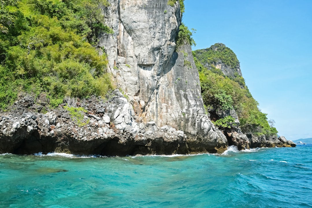 gray rock formation beside body of water during daytime