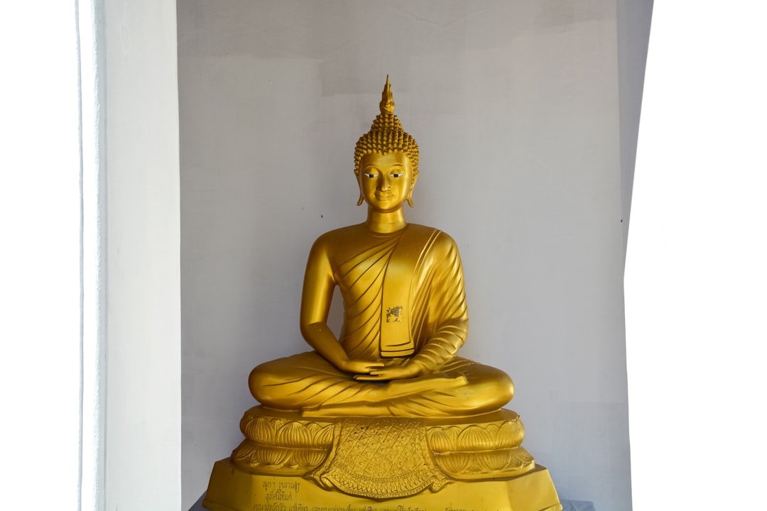 gold buddha figurine on white table