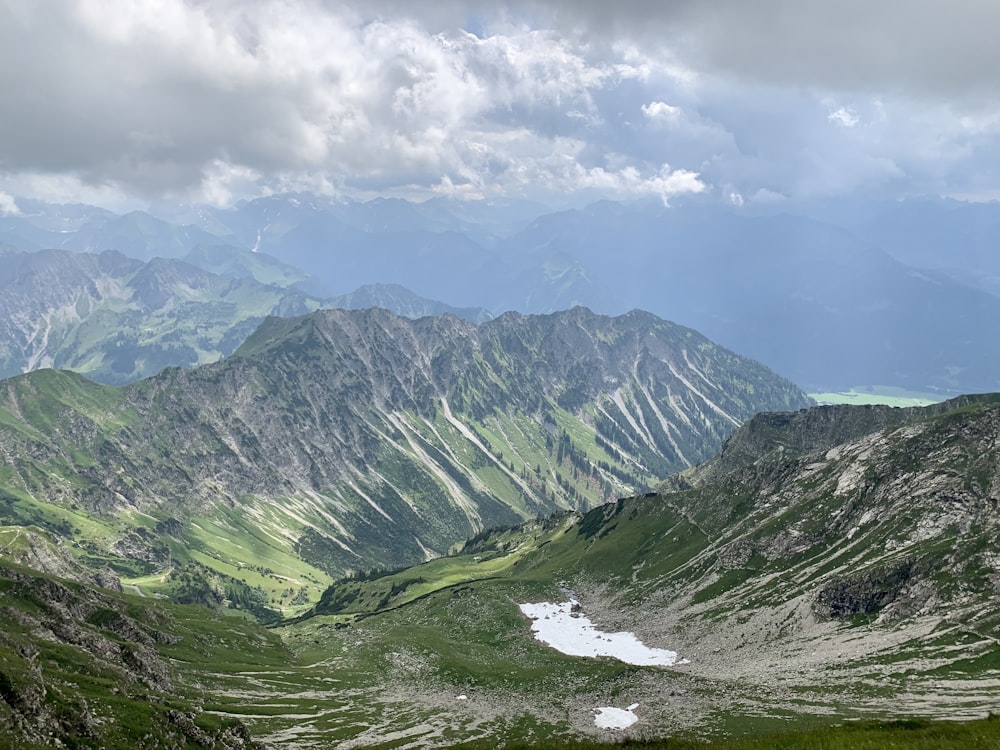 green and gray mountains under white clouds and blue sky during daytime