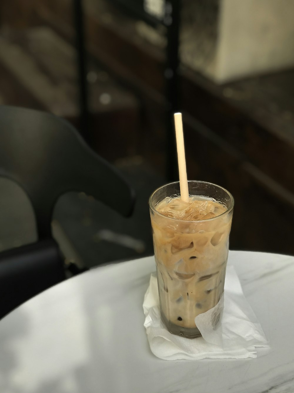 clear drinking glass with brown liquid on white ceramic plate