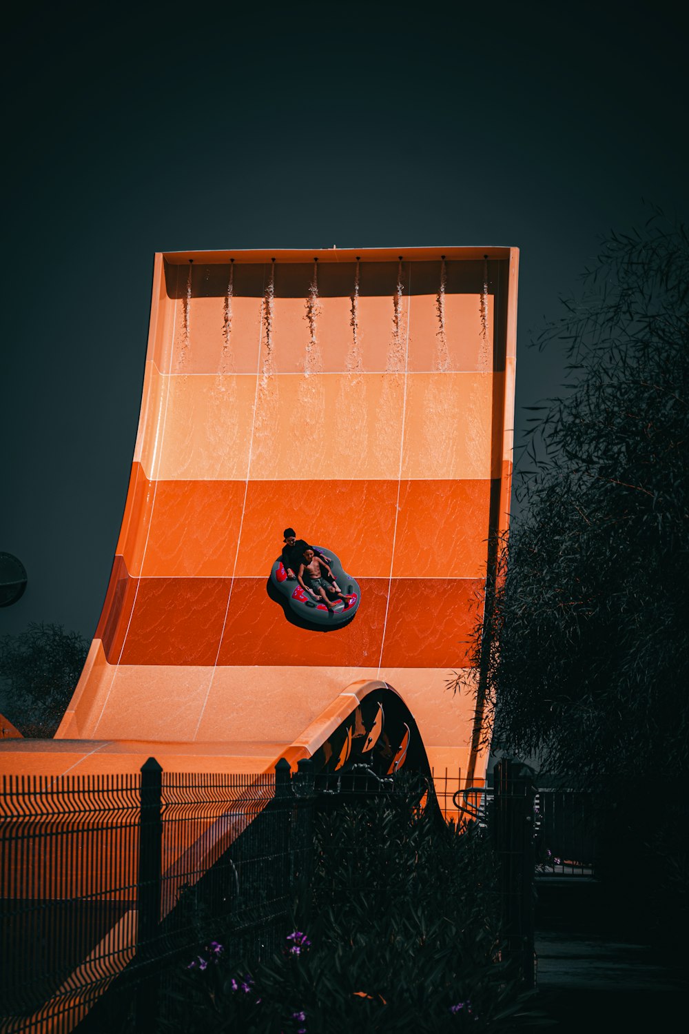 man in black jacket lying on blue and orange concrete wall