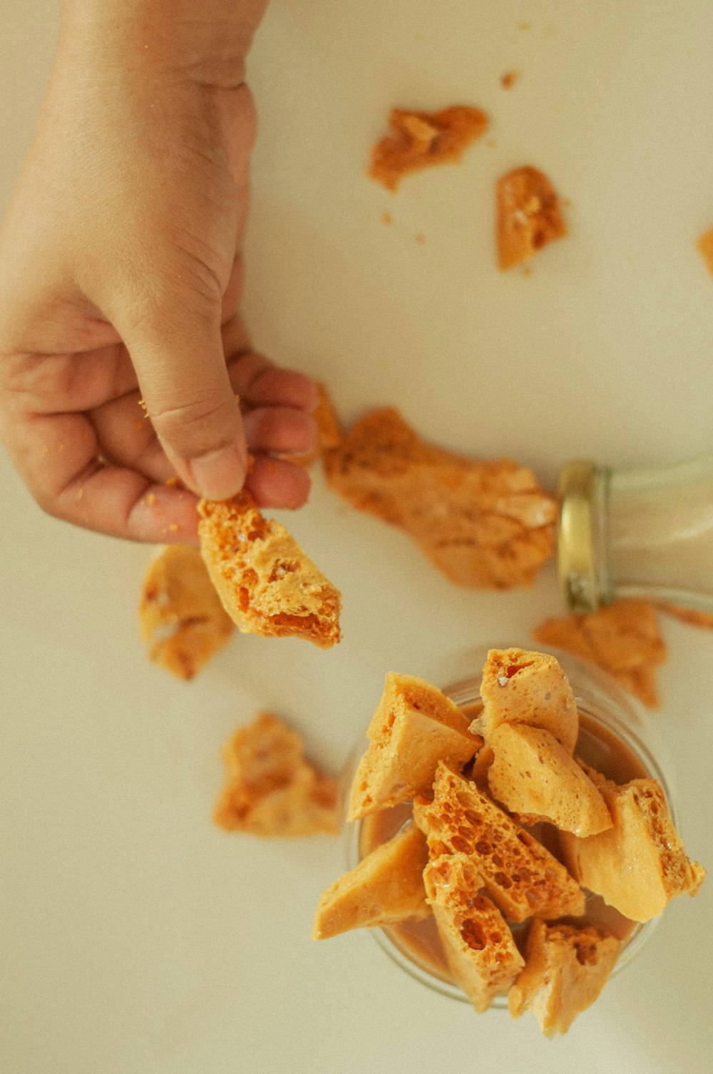 person holding brown chips on white table