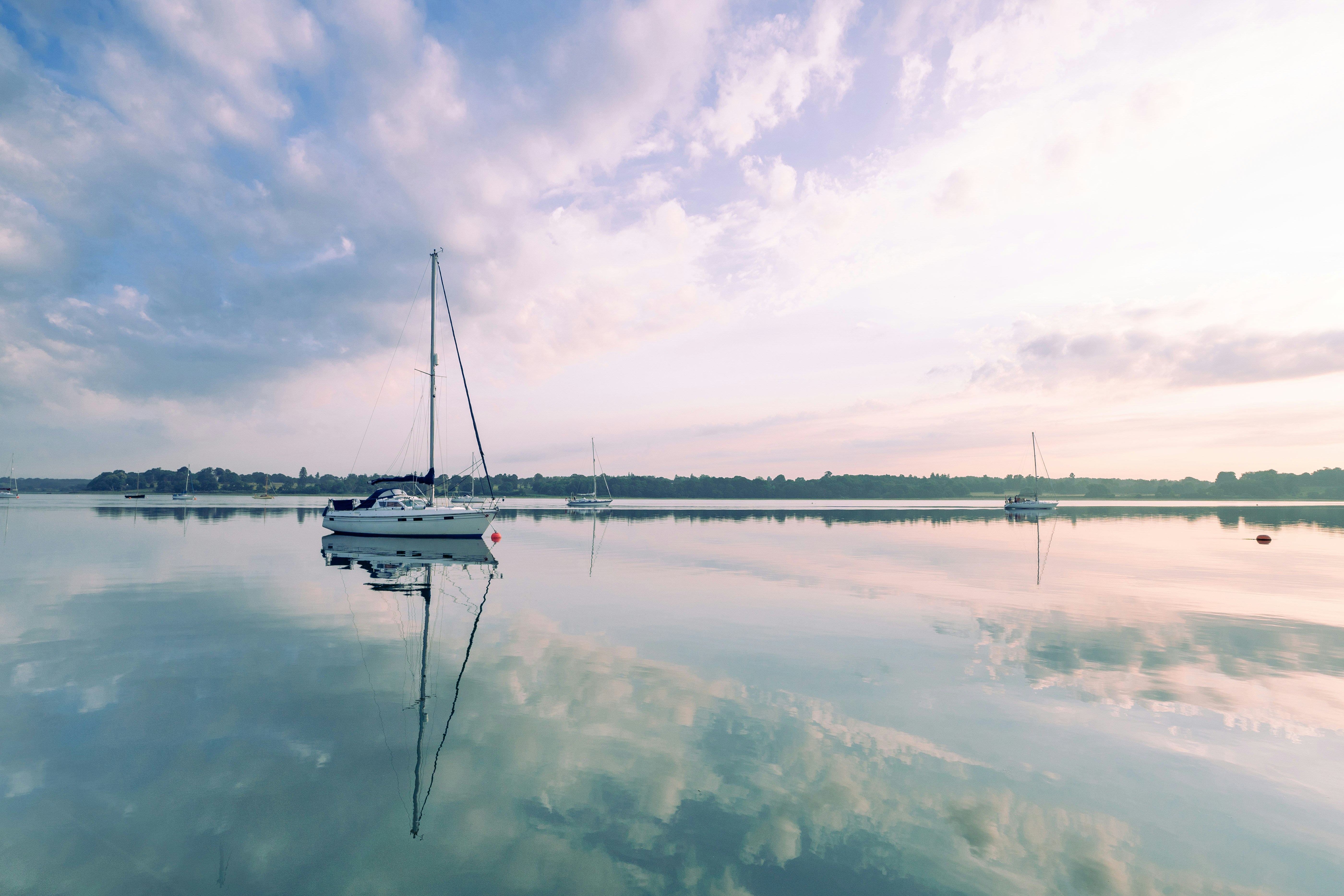 white boat on body of water under cloudy sky during daytime