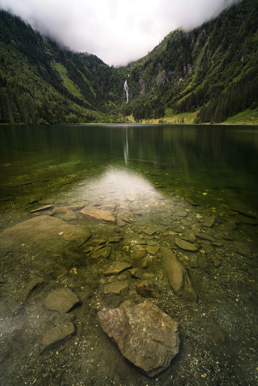 green mountain beside body of water during daytime