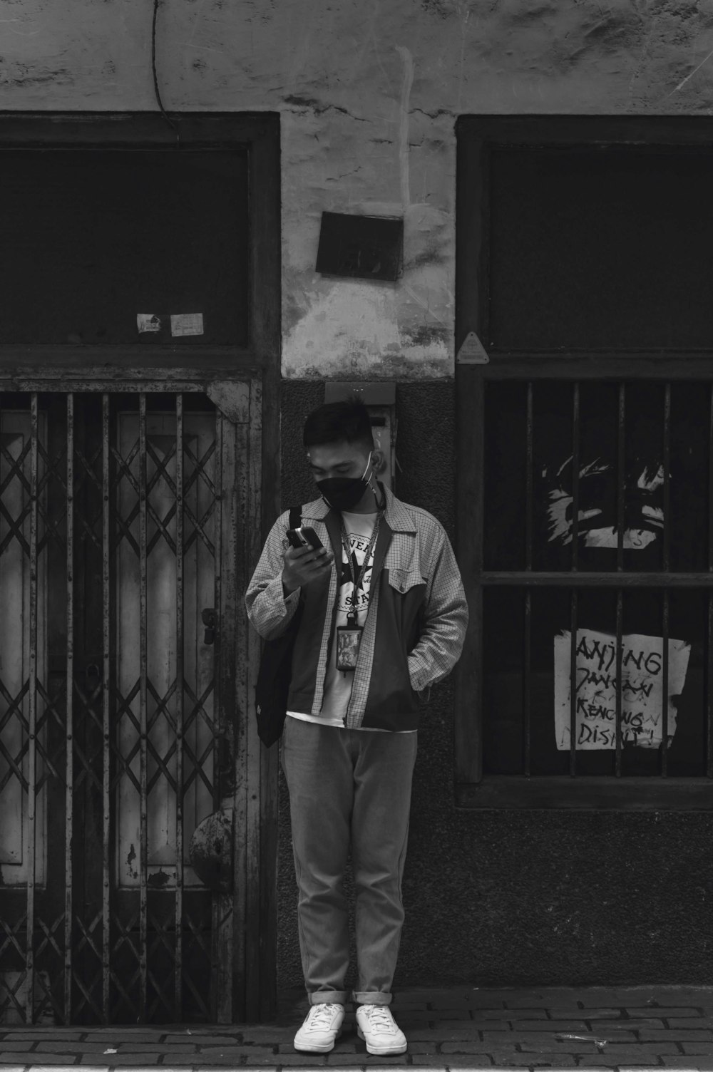 man in black jacket and pants standing beside door