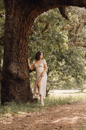 Photo of Letícia Rodrigues consulting outdoors surrounded by trees and green spaces.