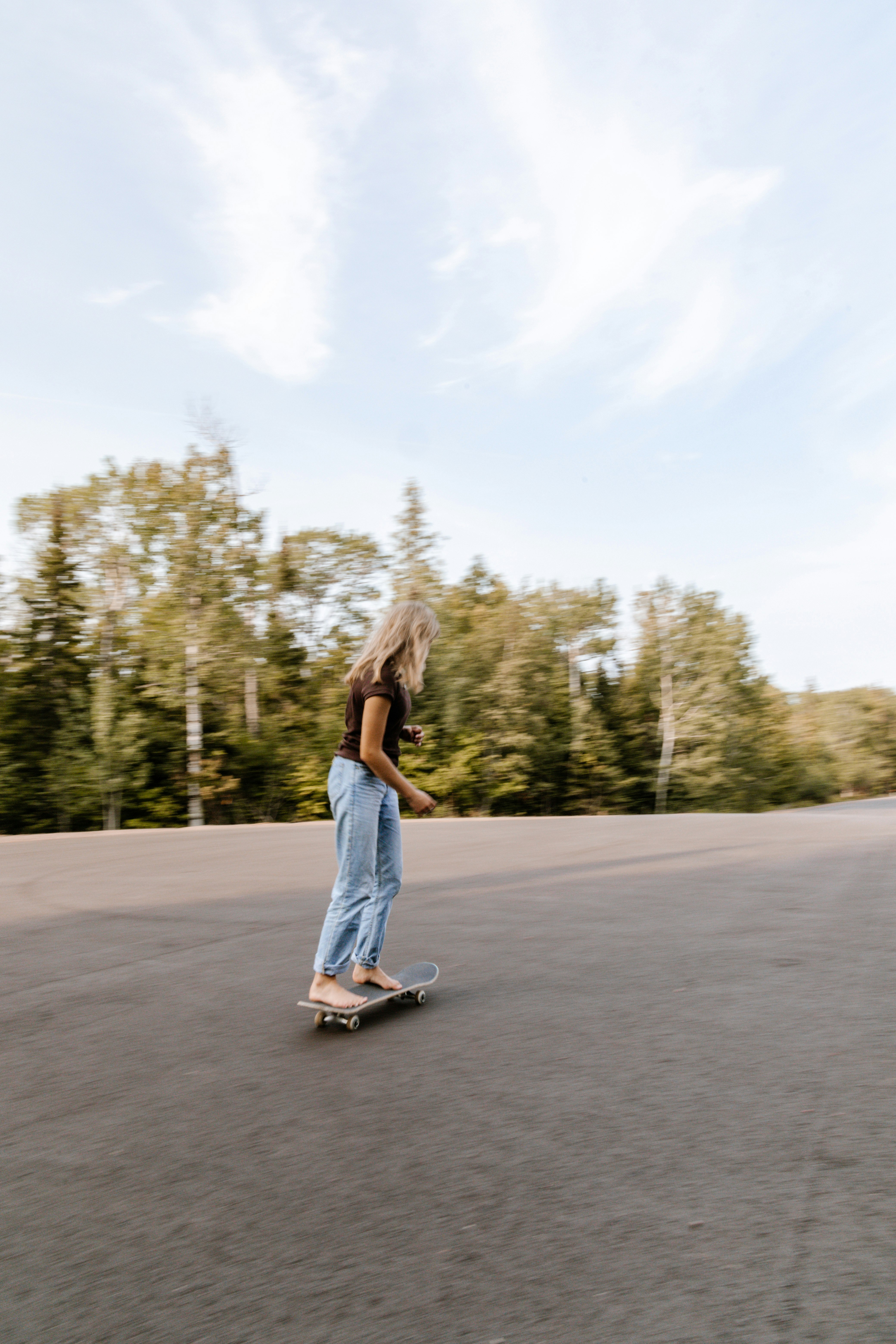 woman in blue denim shorts standing on gray concrete road during daytime