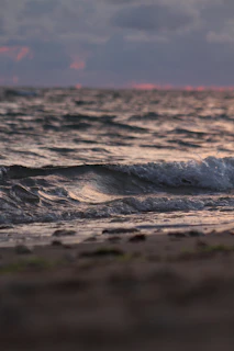 water waves on brown sand during daytime