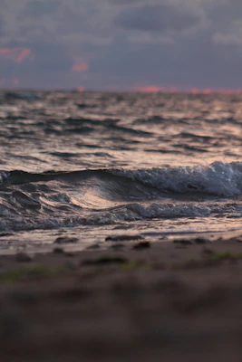 water waves on brown sand during daytime