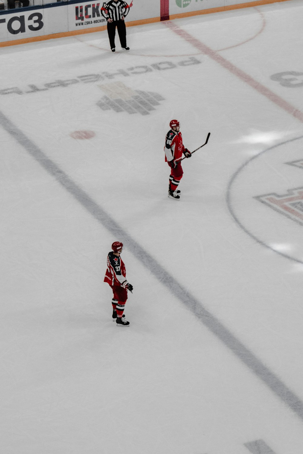 man in red and white jersey shirt and pants playing ice hockey