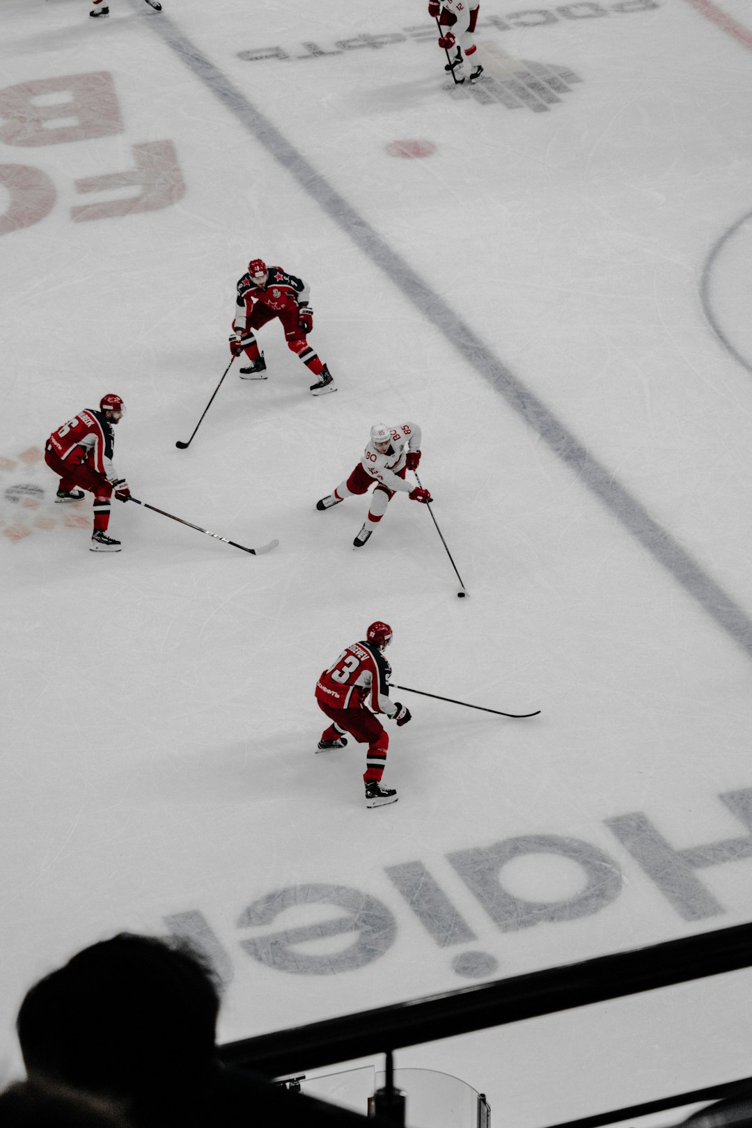 people playing ice hockey on snow field during daytime