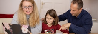 woman in blue sweater beside girl in blue sweater