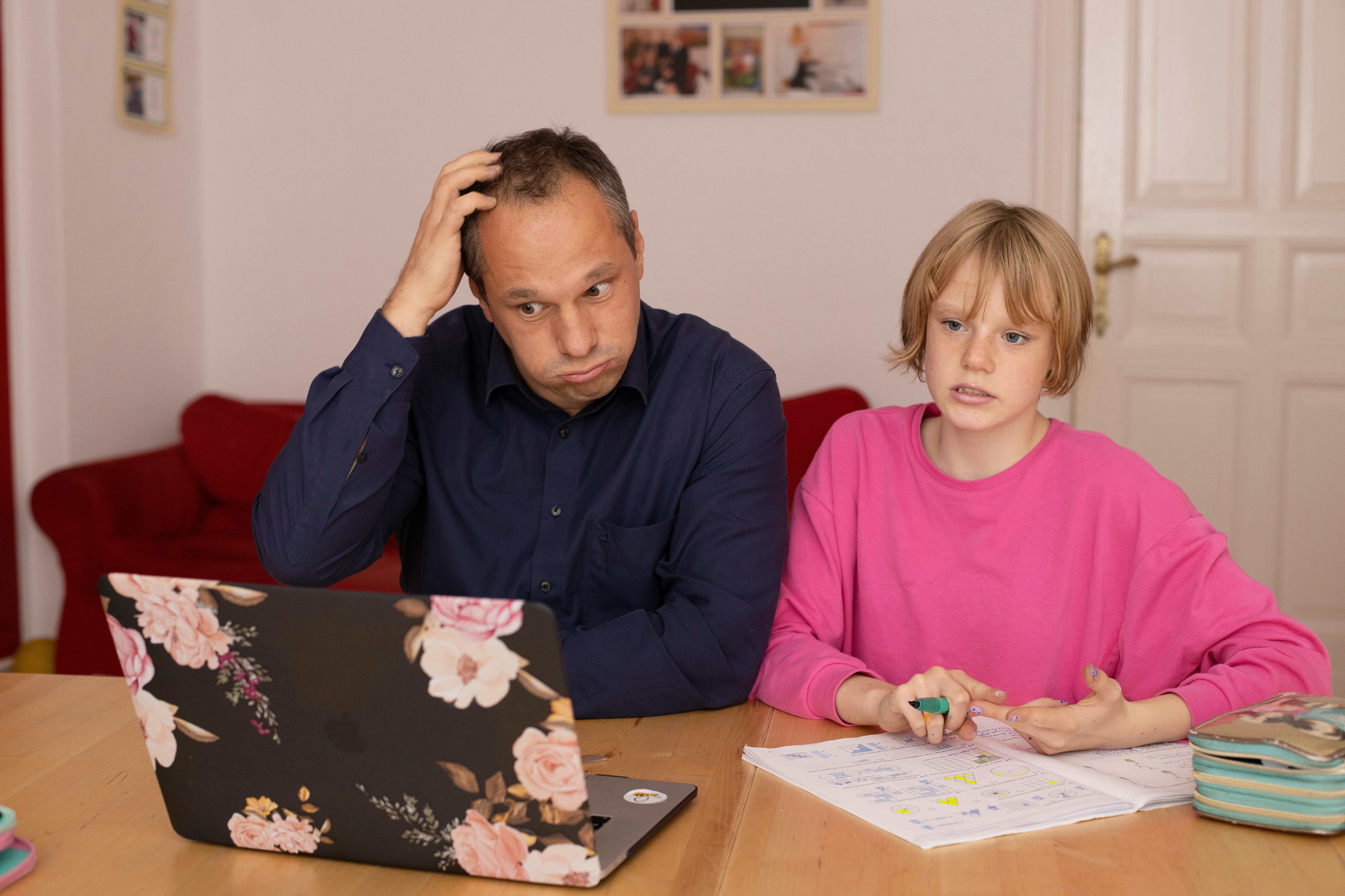 Perplexed father during homeschooling with his daughter.