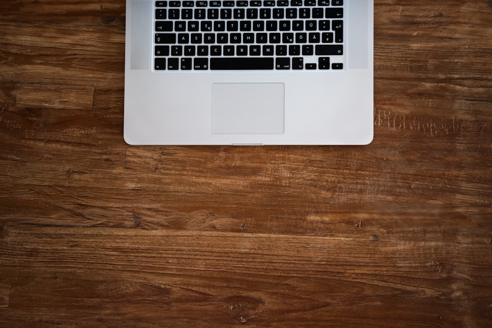 macbook pro on brown wooden table