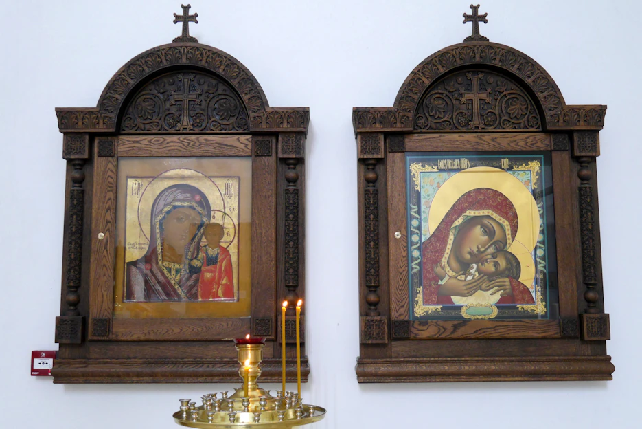 Handcrafted wooden frame with intricate religious art displayed in a cozy Puebla home setting