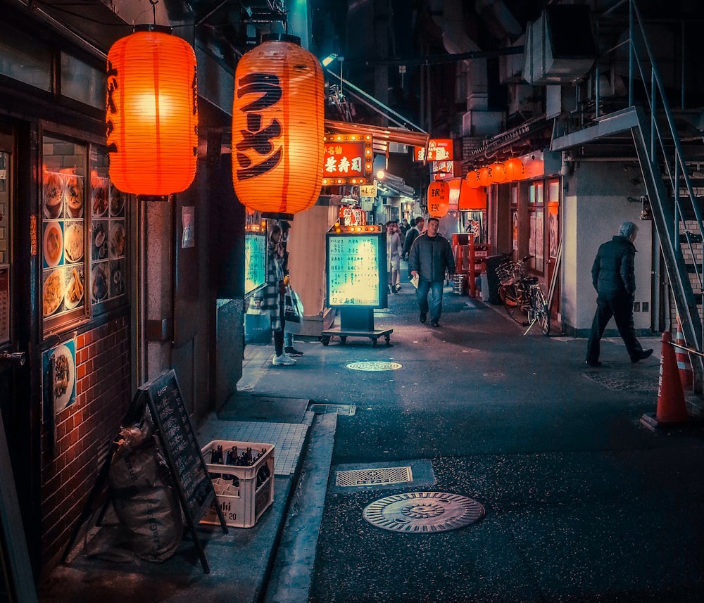 man in black jacket walking on sidewalk during nighttime