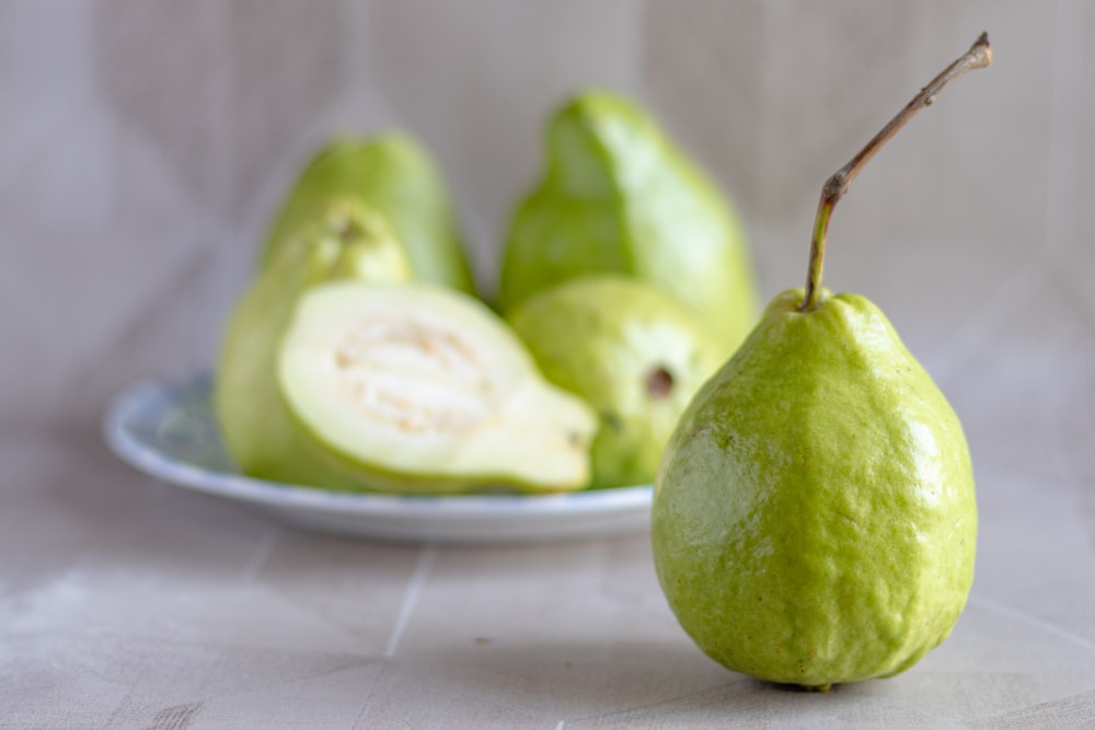 green fruit on white ceramic plate