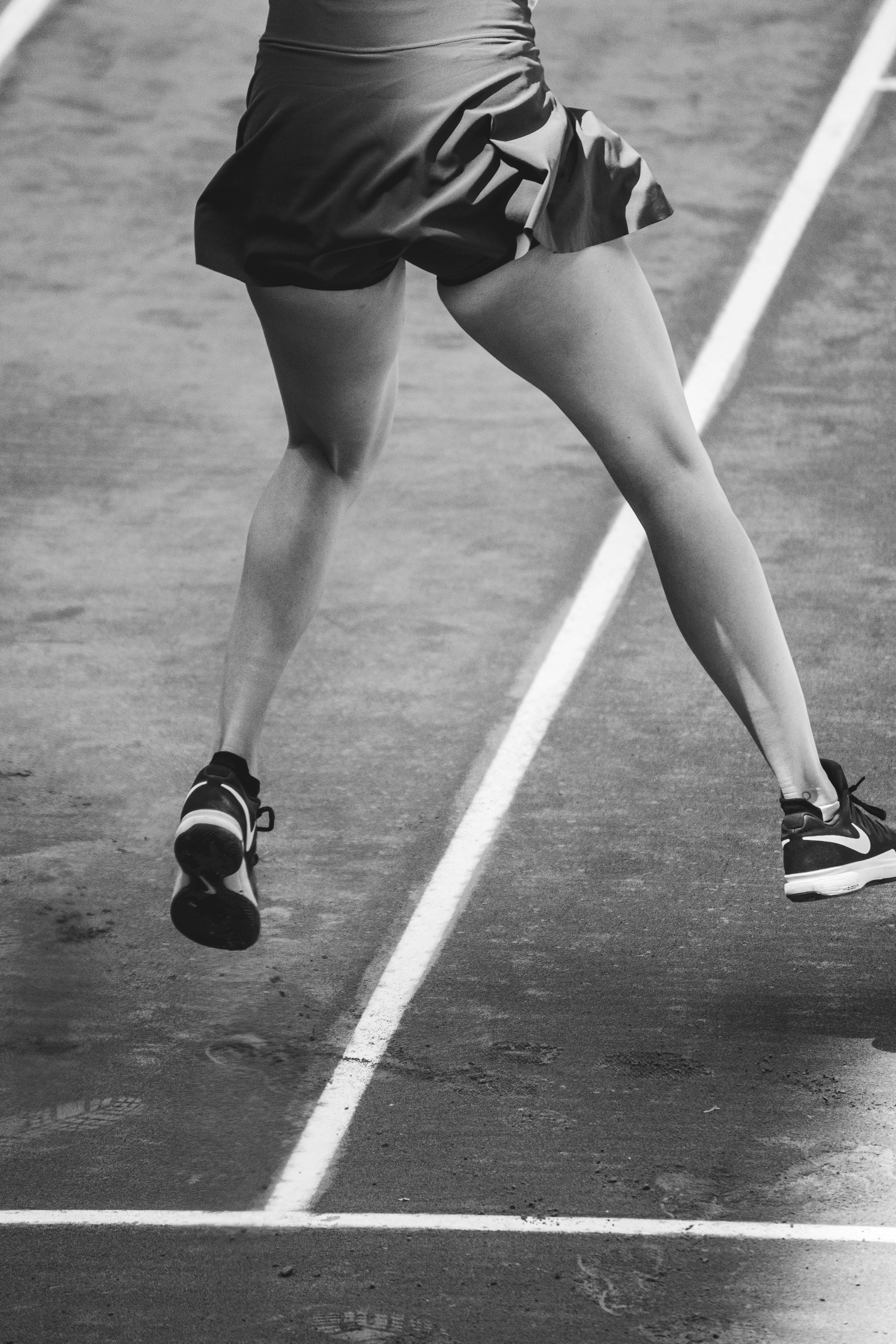 Foto skala abu-abu orang yang mengenakan sepatu Nike
