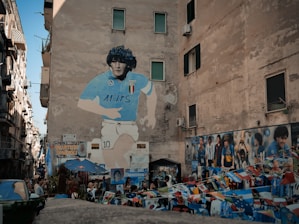 man in blue and white crew neck t-shirt standing on the street