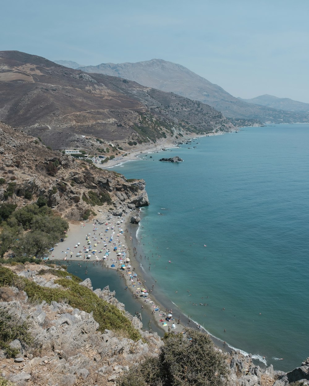 aerial view of green and brown mountain beside blue sea during daytime