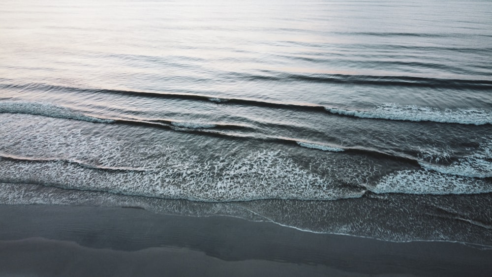 ocean waves crashing on shore during daytime