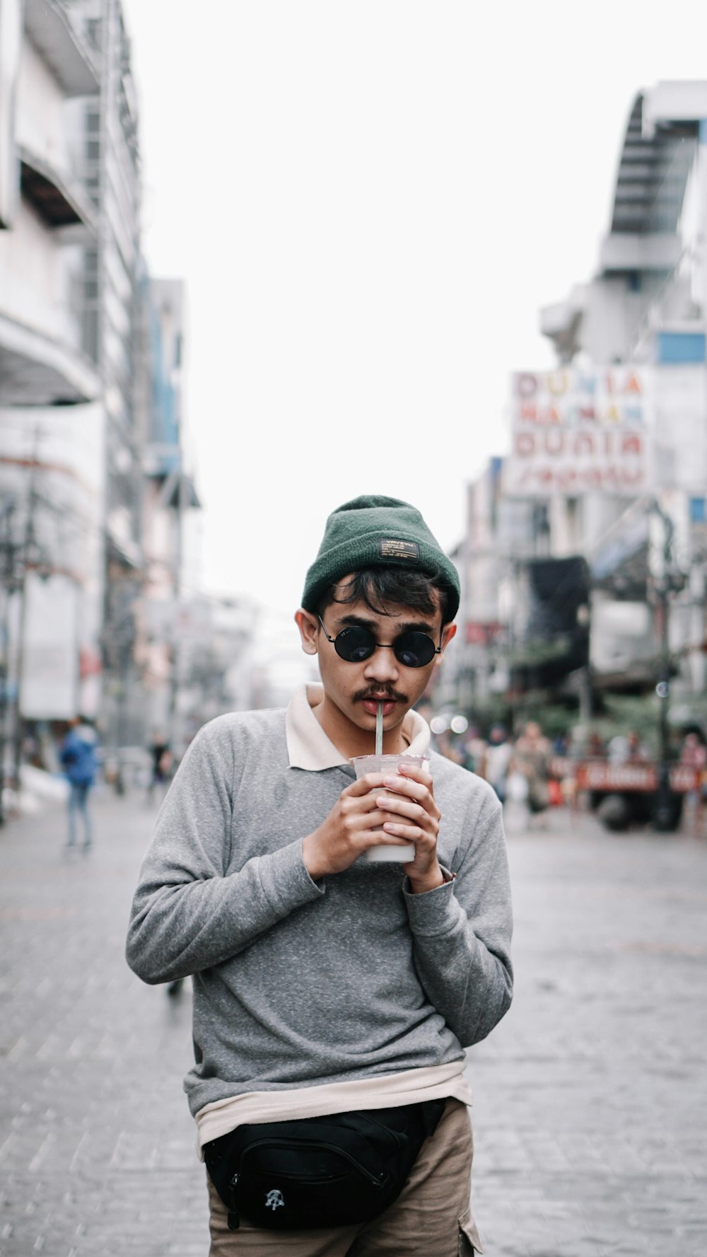 homme en pull gris et casquette verte tenant un cornet de crème glacée  photo – Photo Città di bandung Gratuite sur Unsplash