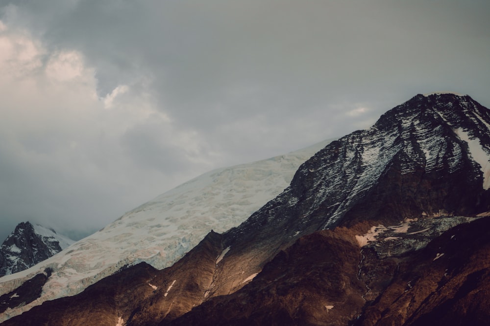 brown and gray rocky mountain under white clouds during daytime