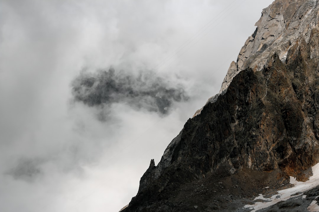 brown rocky mountain with white clouds