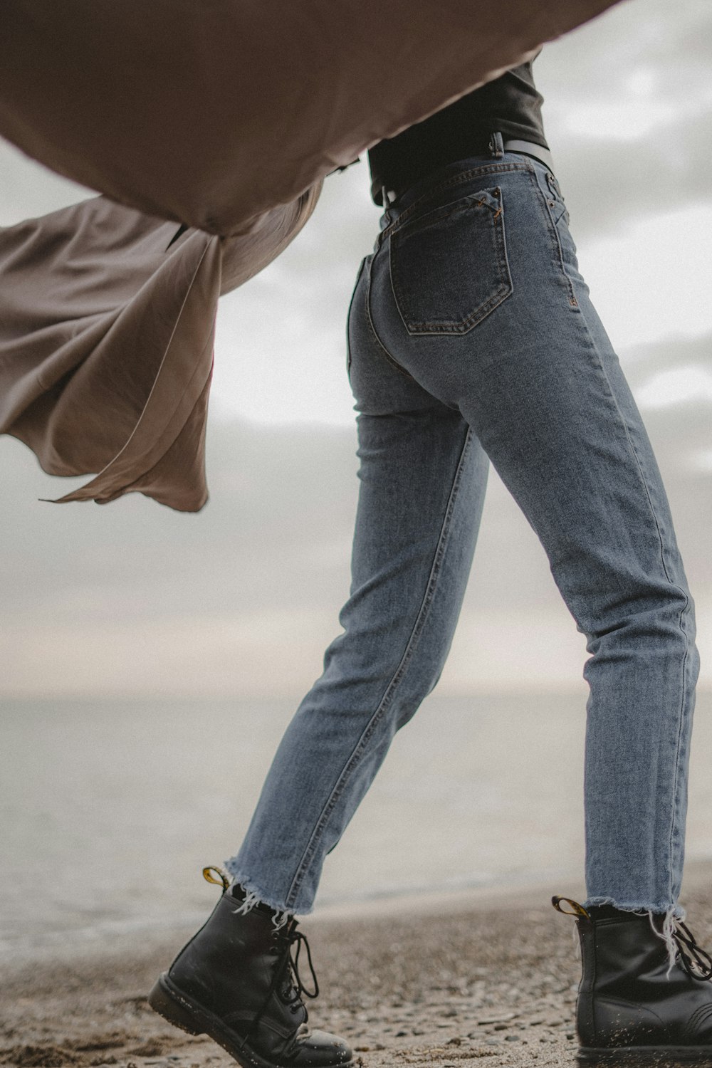 person in blue denim jeans and brown jacket