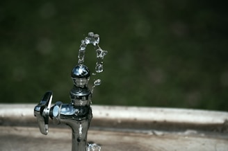 silver faucet with water droplets